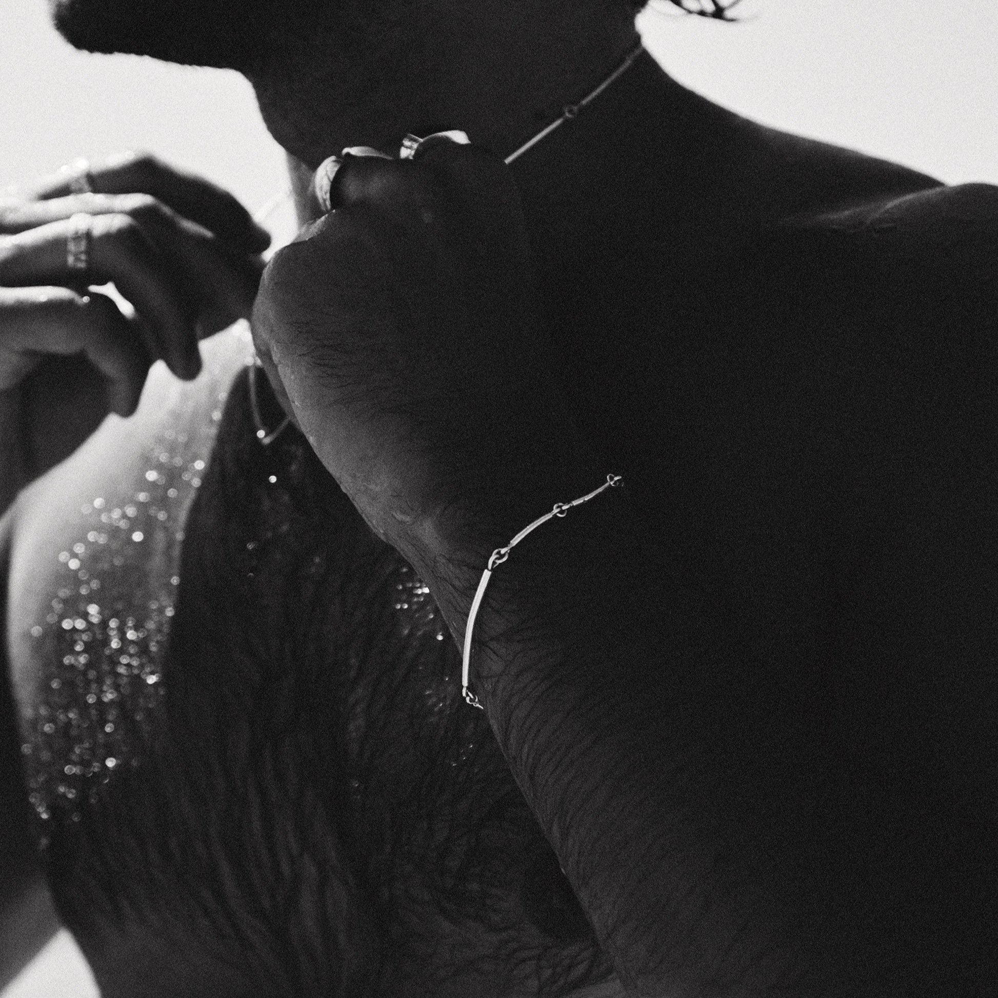 Black and white close-up of a person wearing jewelry with a blurred background