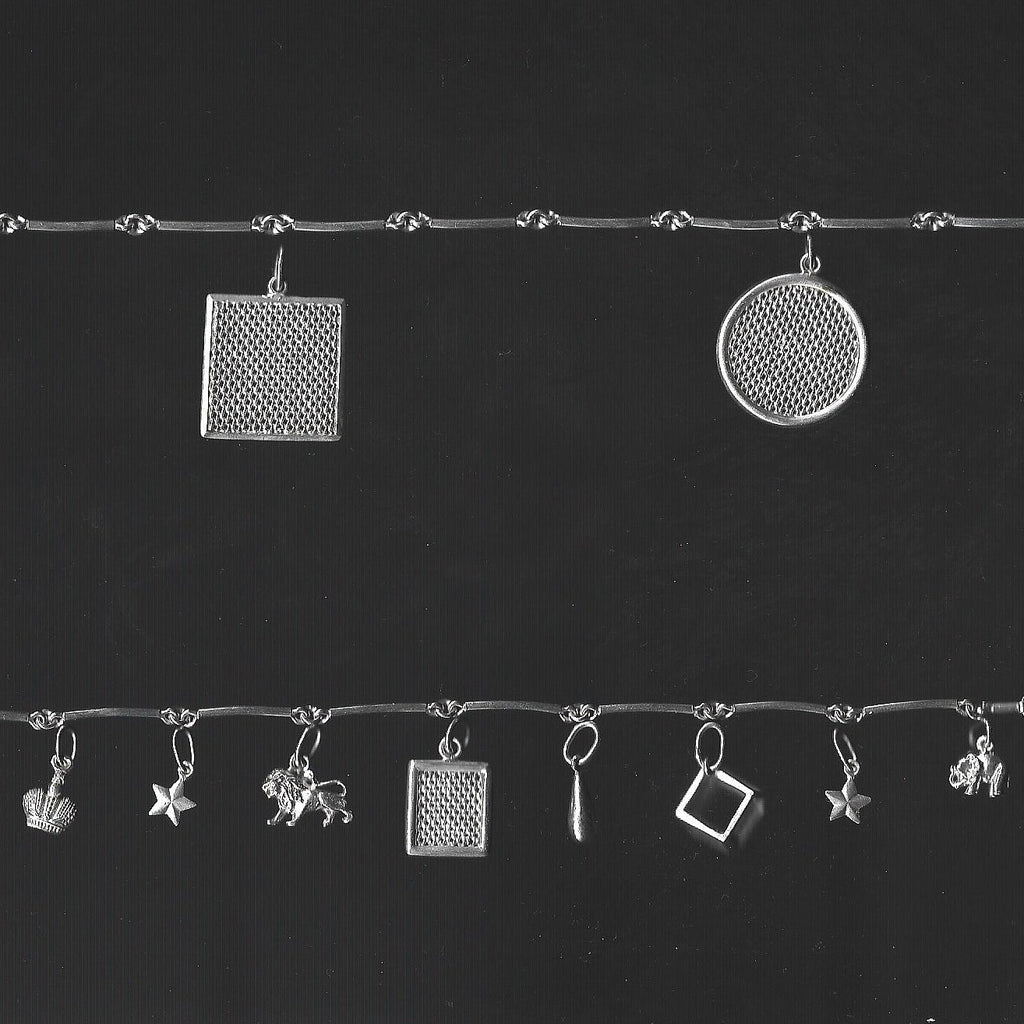 Silver jewelry charms on a black background