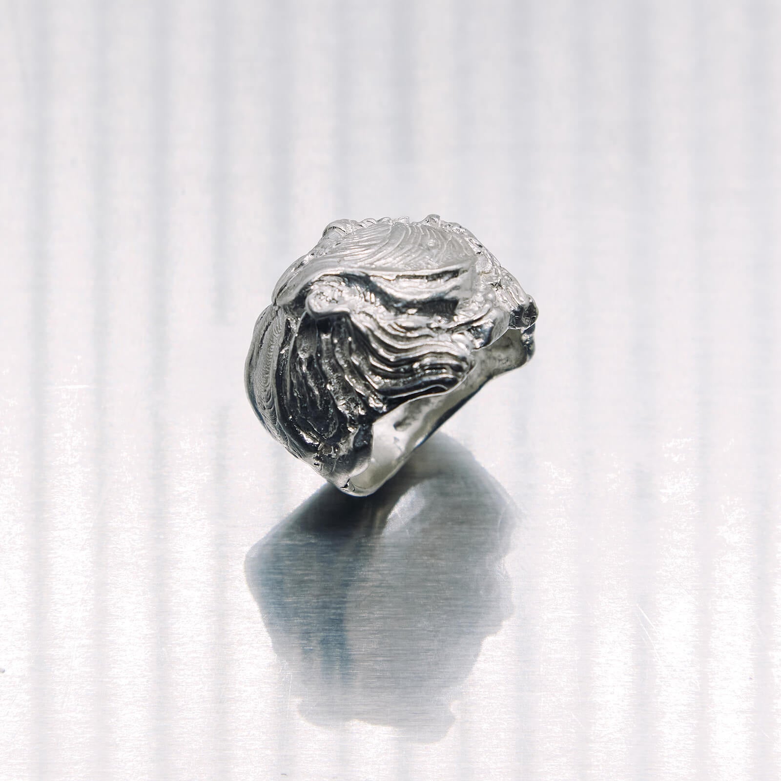 Silver ring with wave design on a white background