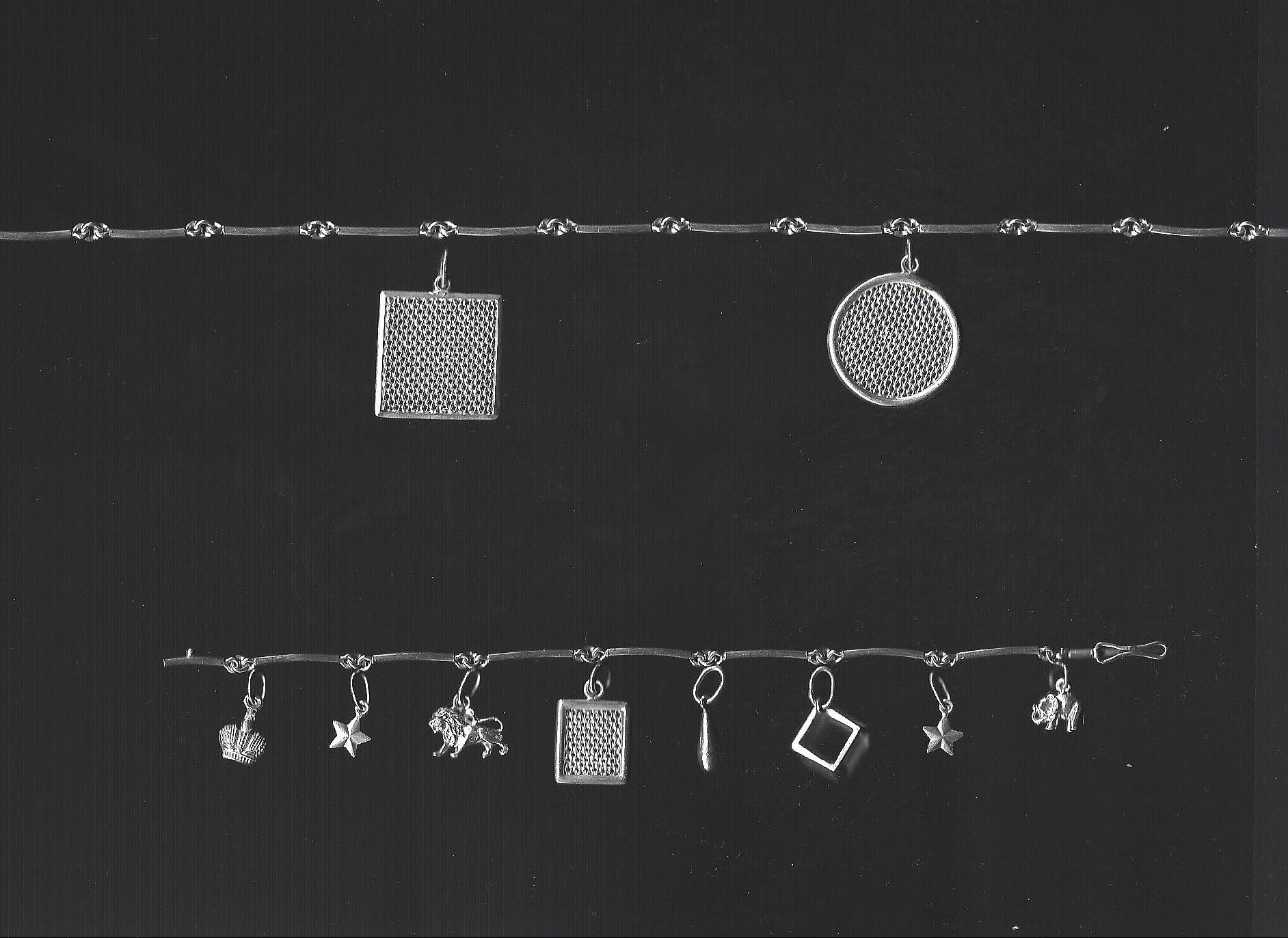 Silver jewelry charms on a black background