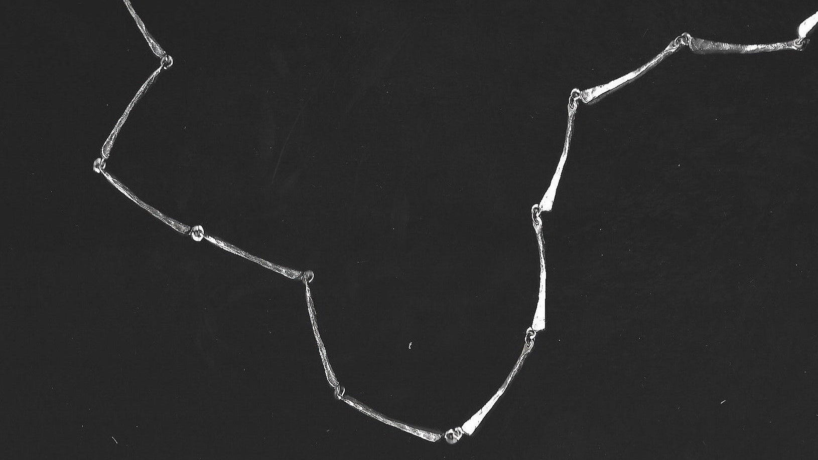 Silver necklace on a black background