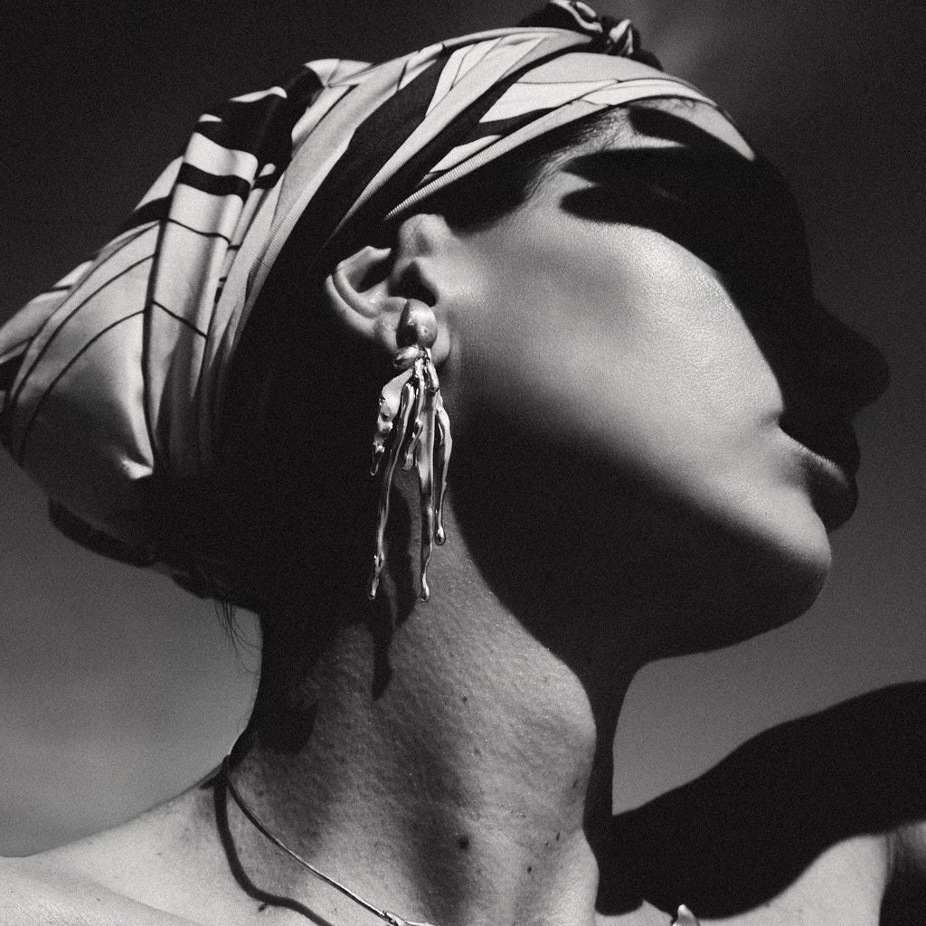 Black and white portrait of a woman wearing jewelry with a blurred background