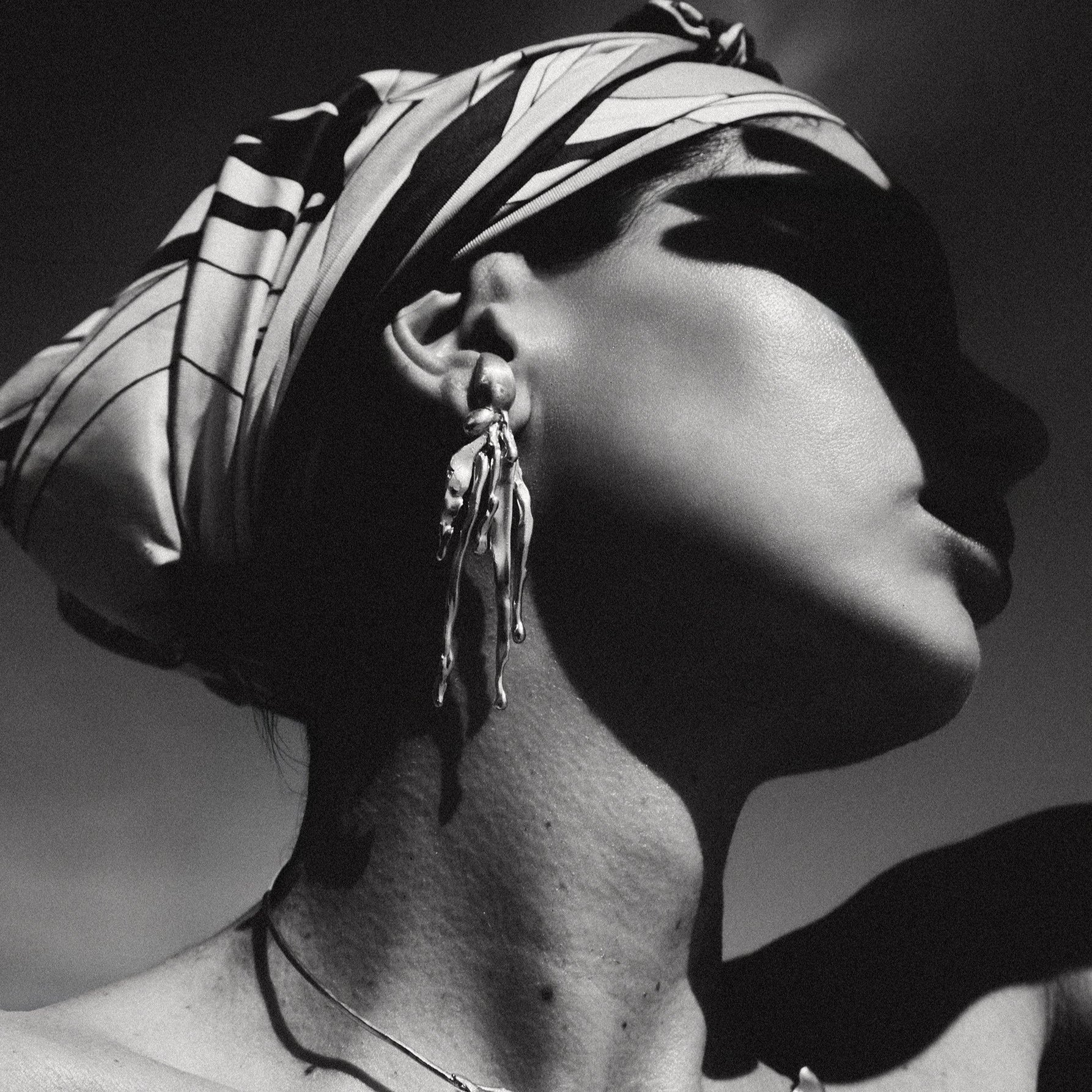 Black and white portrait of a woman wearing jewelry with a blurred background