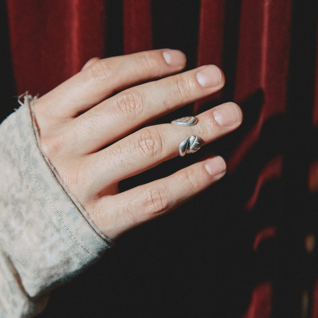 Hand wearing a ring with a dark background
