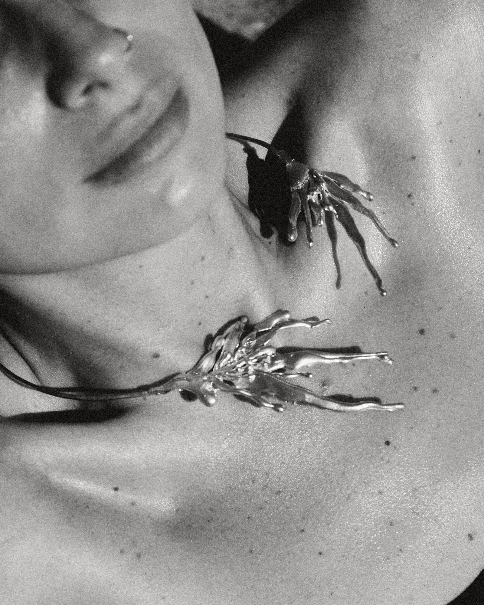 Close-up of a person wearing a unique necklace with a detailed design.