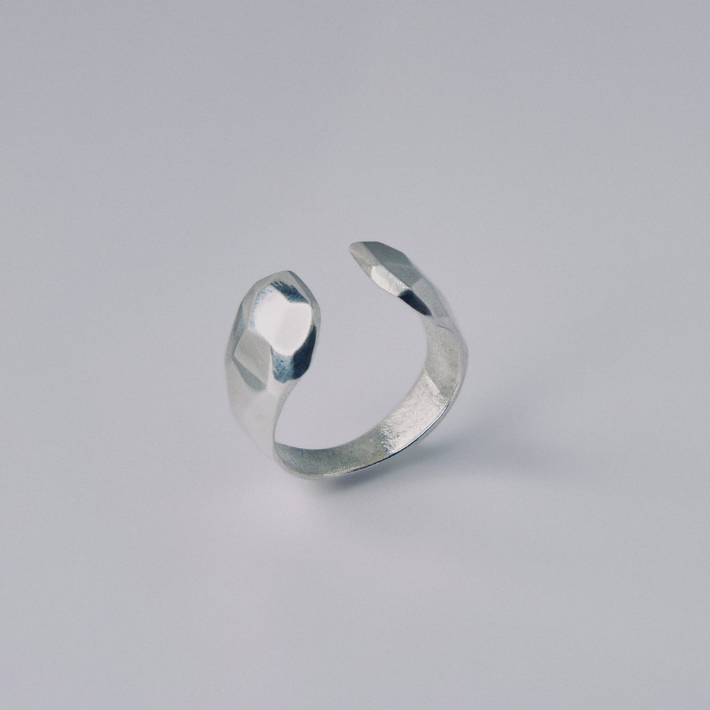Silver open ring on a light gray background