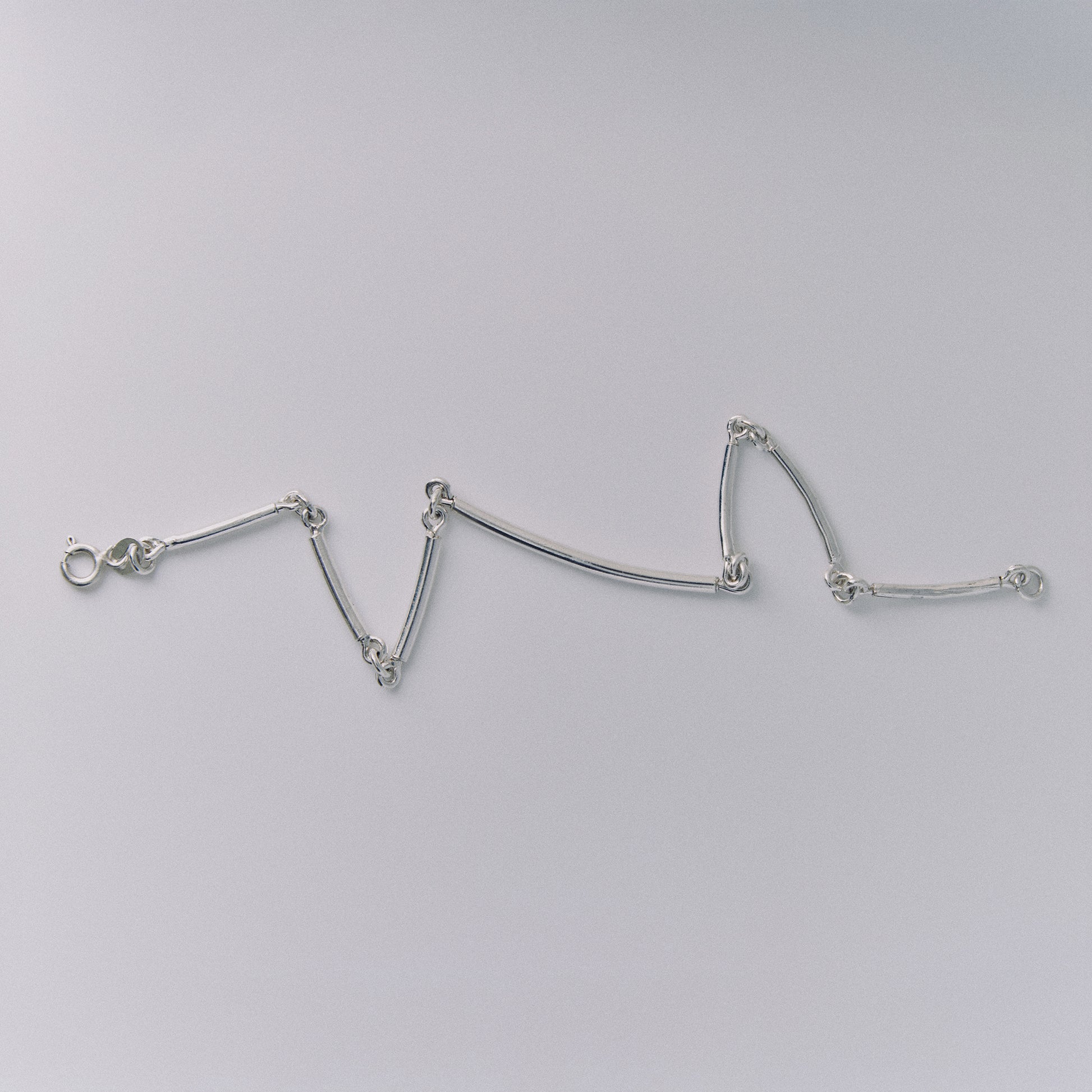 Silver bracelet on a light gray background