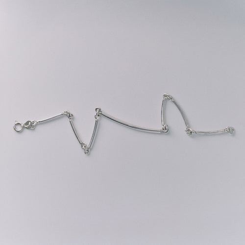 Silver bracelet on a light gray background