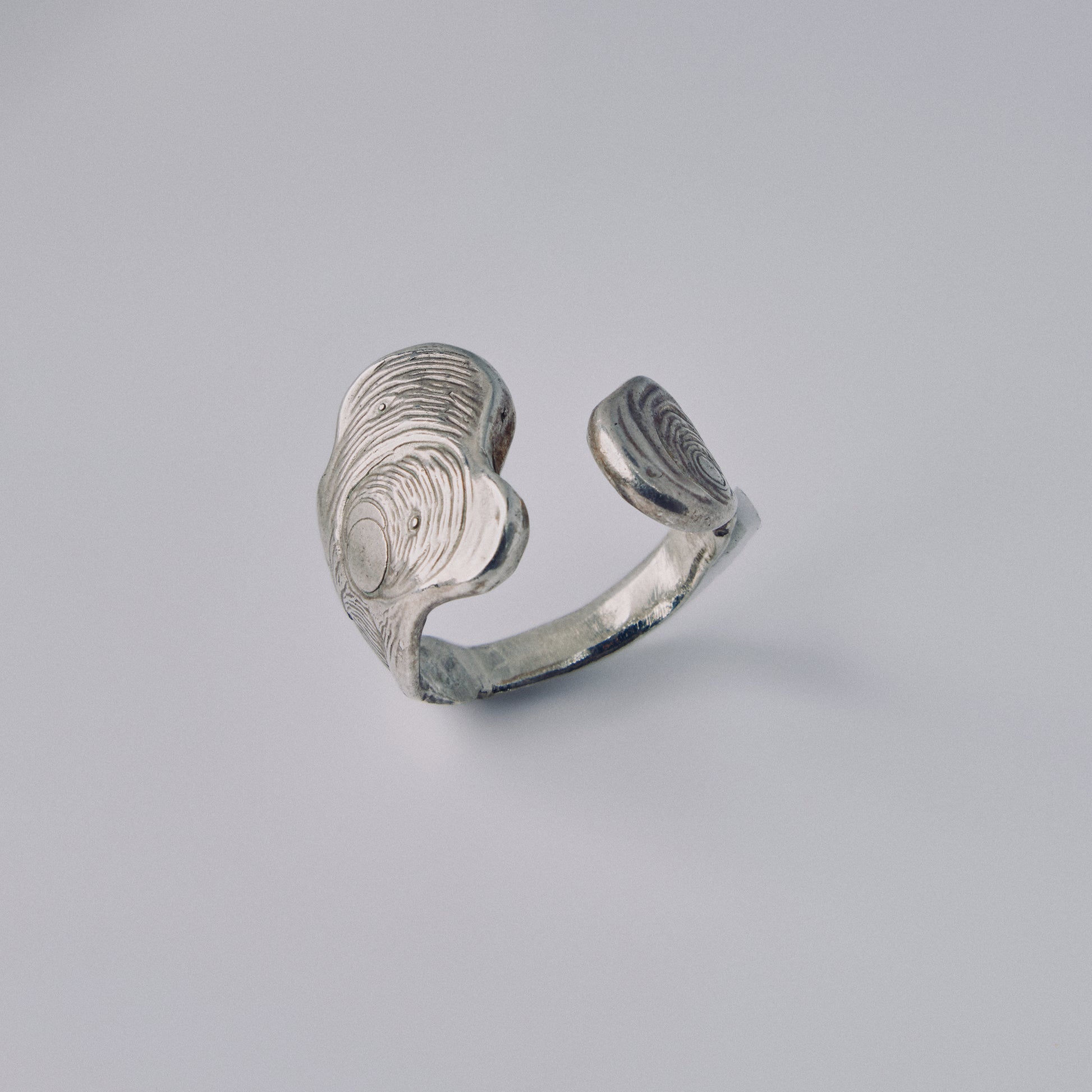 Silver openwork ring on a light gray background
