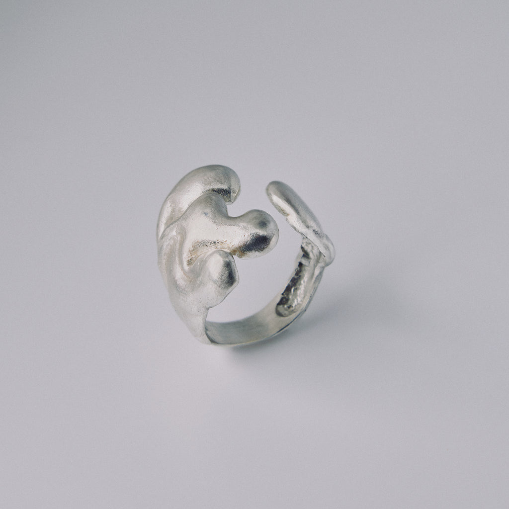 Silver ring with a unique design on a gray background