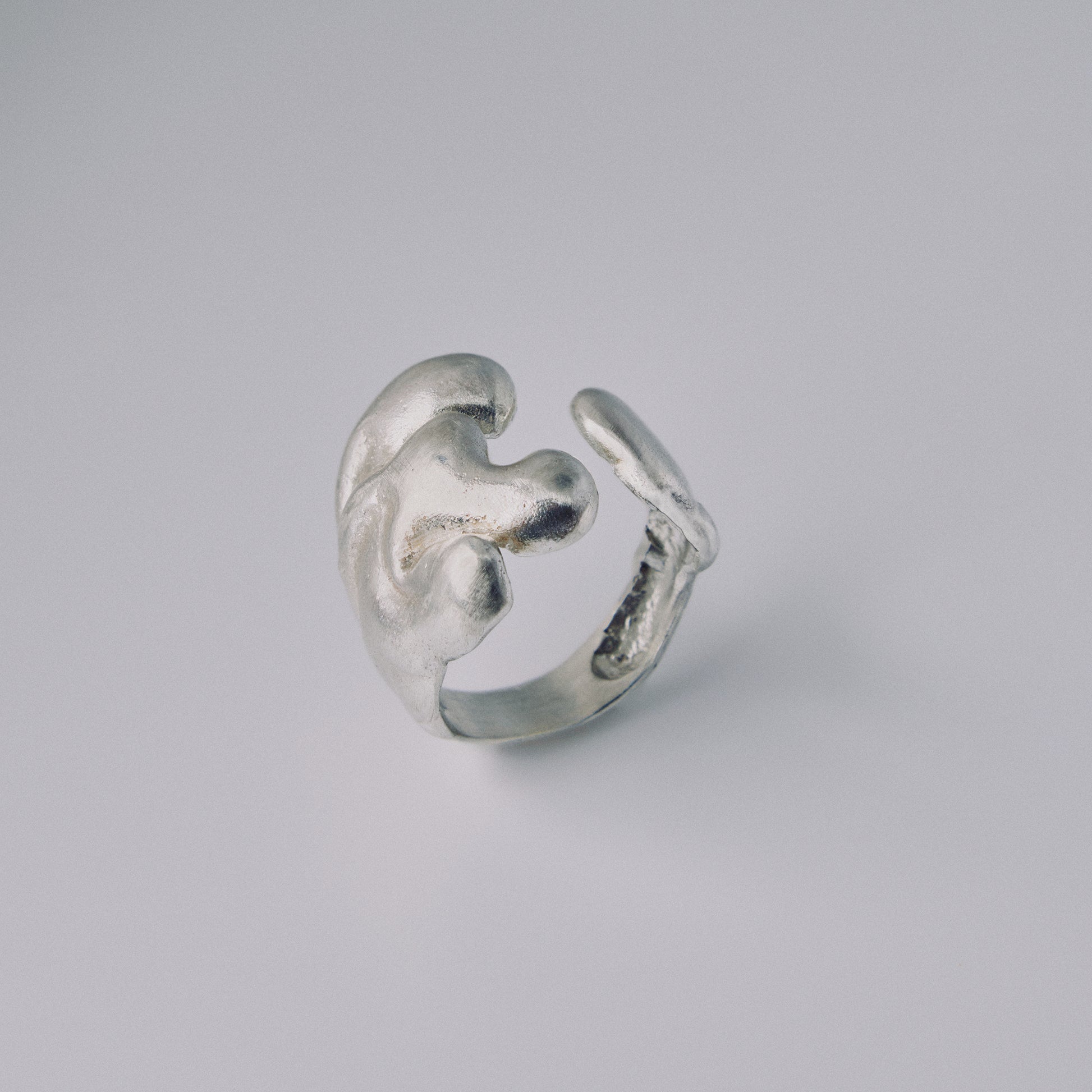 Silver ring with a unique design on a gray background