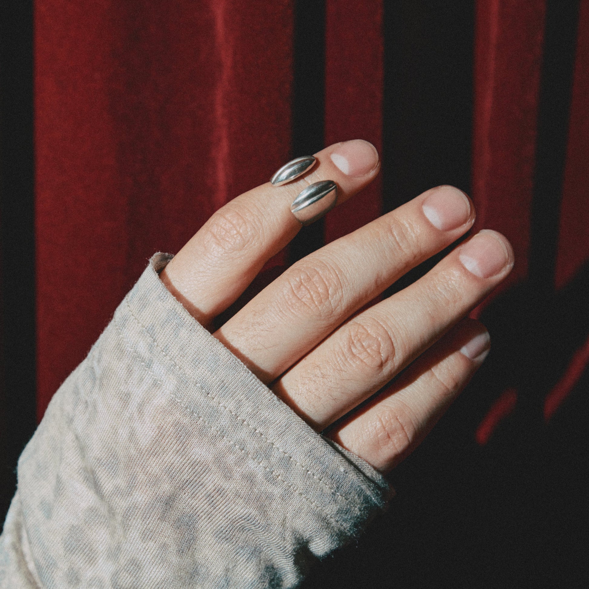 Hand wearing a textured glove with a blurred red background