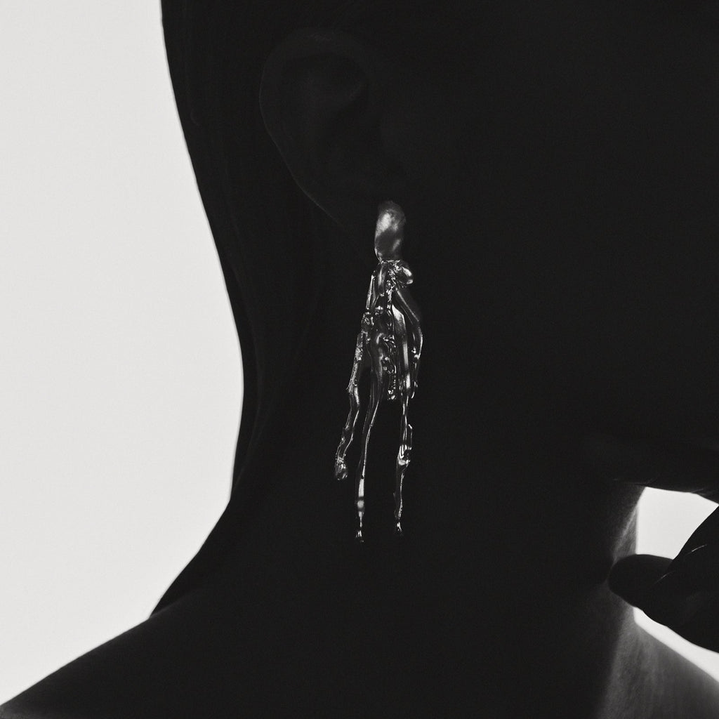 Silhouette of a person with a small, detailed figure on their neck against a light background