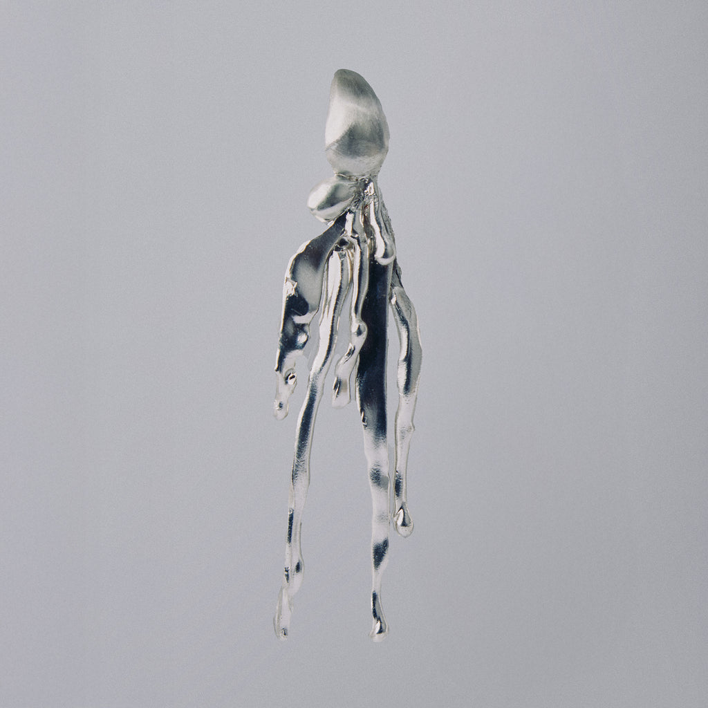 Silver octopus-shaped pendant on a gray background