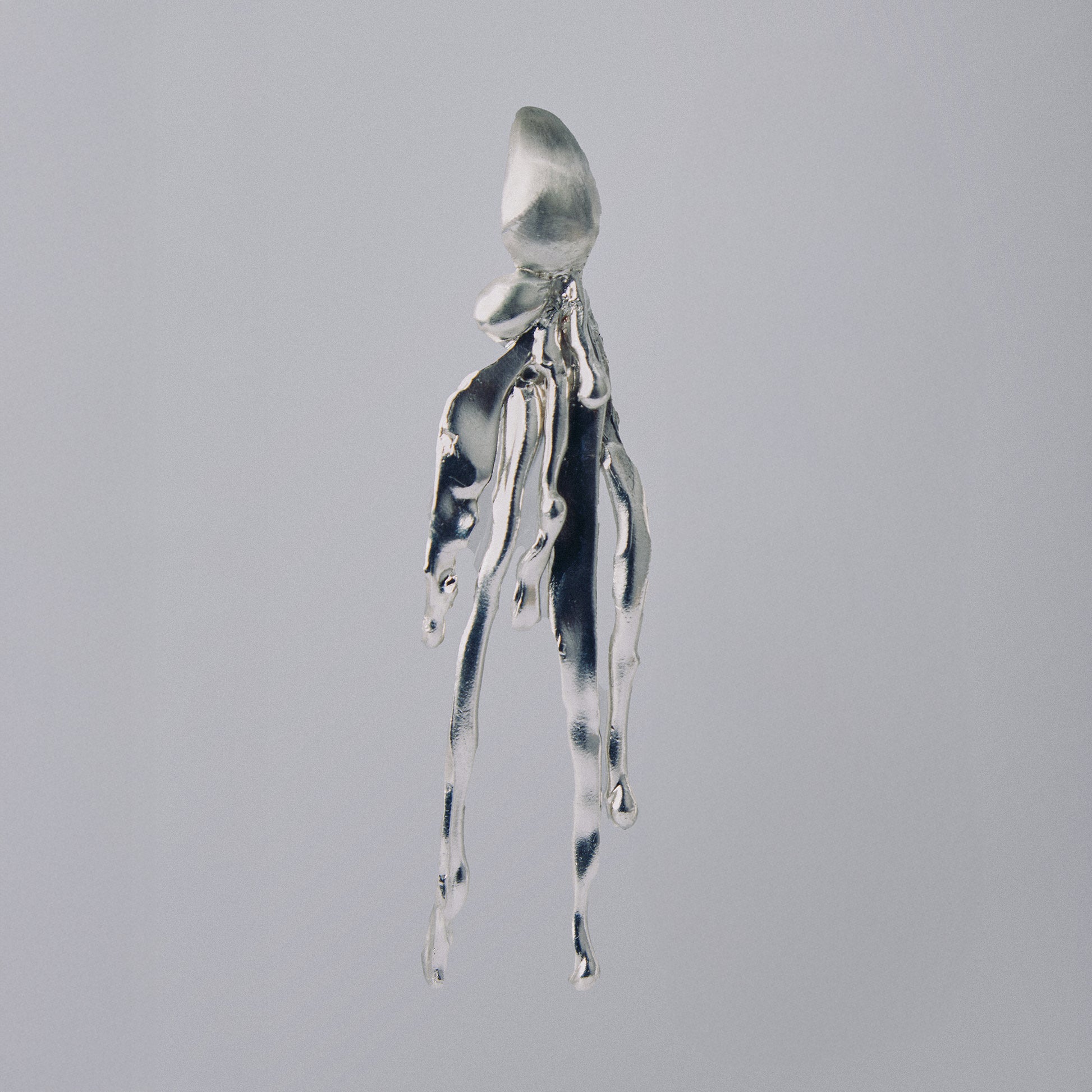 Silver octopus-shaped pendant on a gray background
