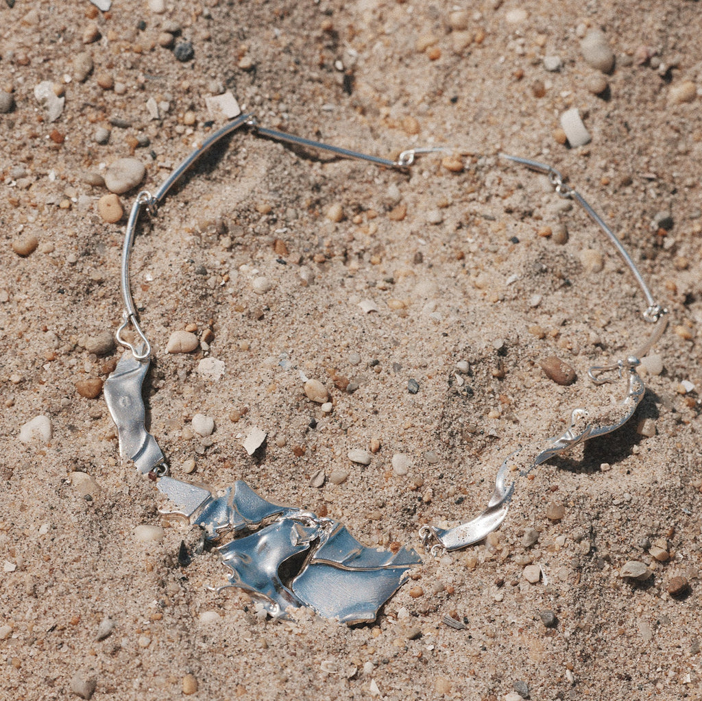 Broken necklace on a sandy surface