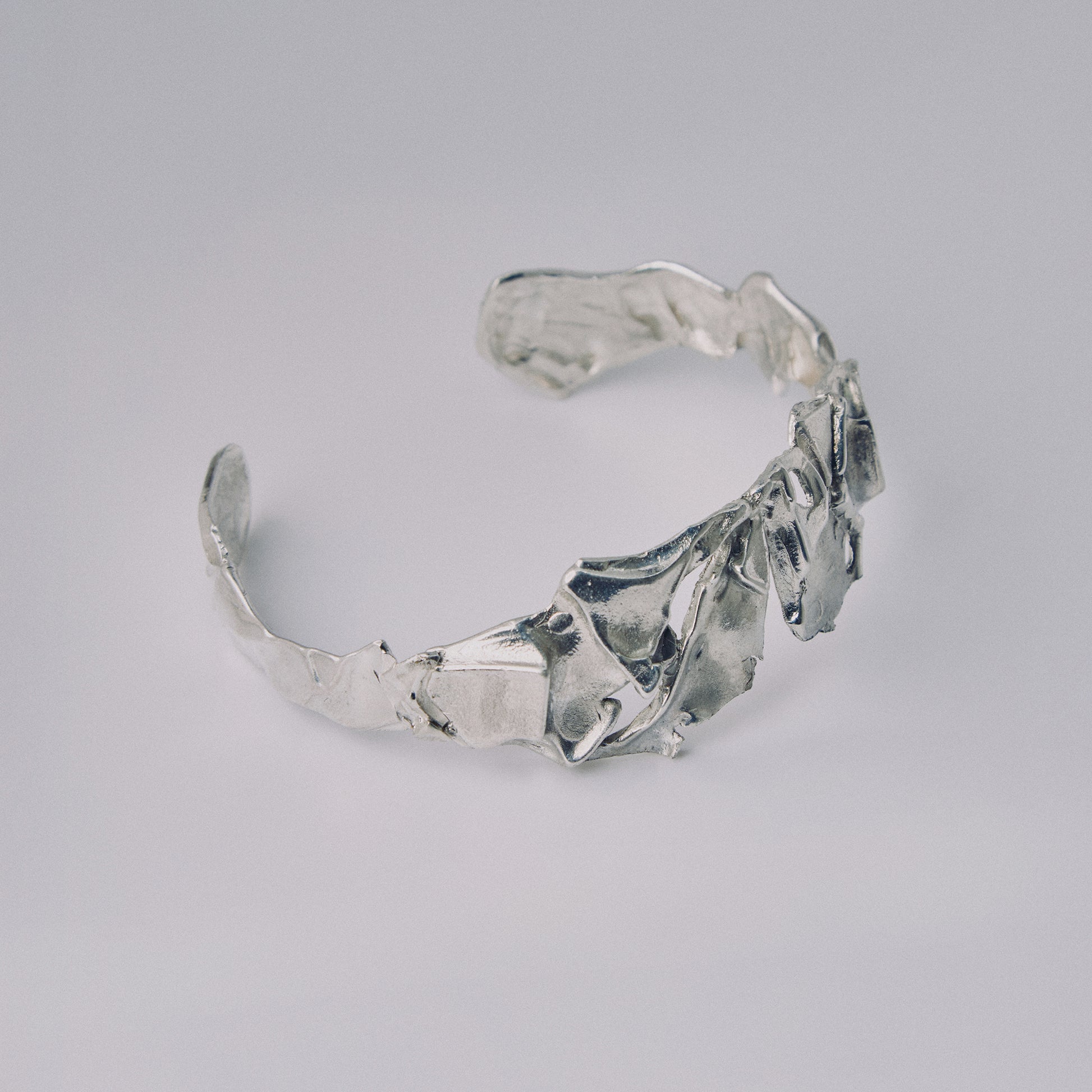 Silver bracelet on a light gray background
