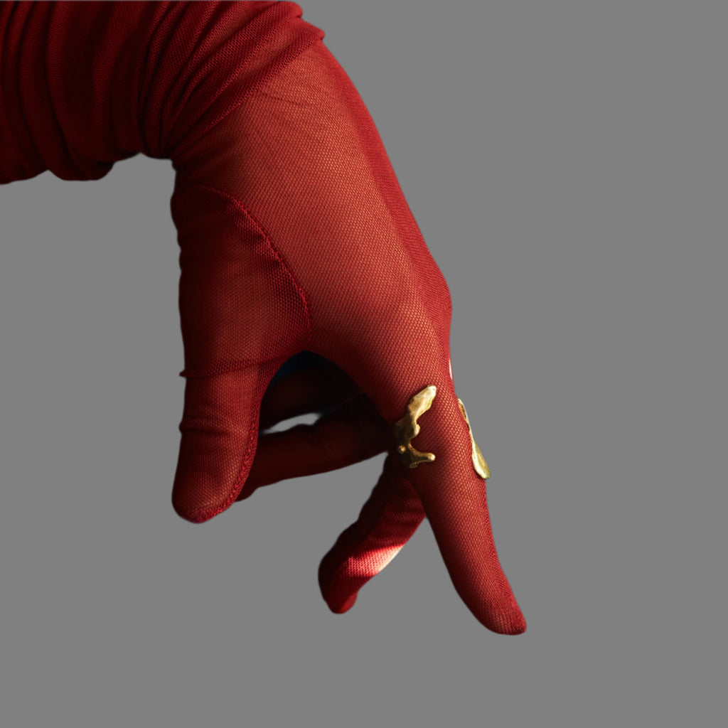Red glove with a gold emblem on a blue curtain background