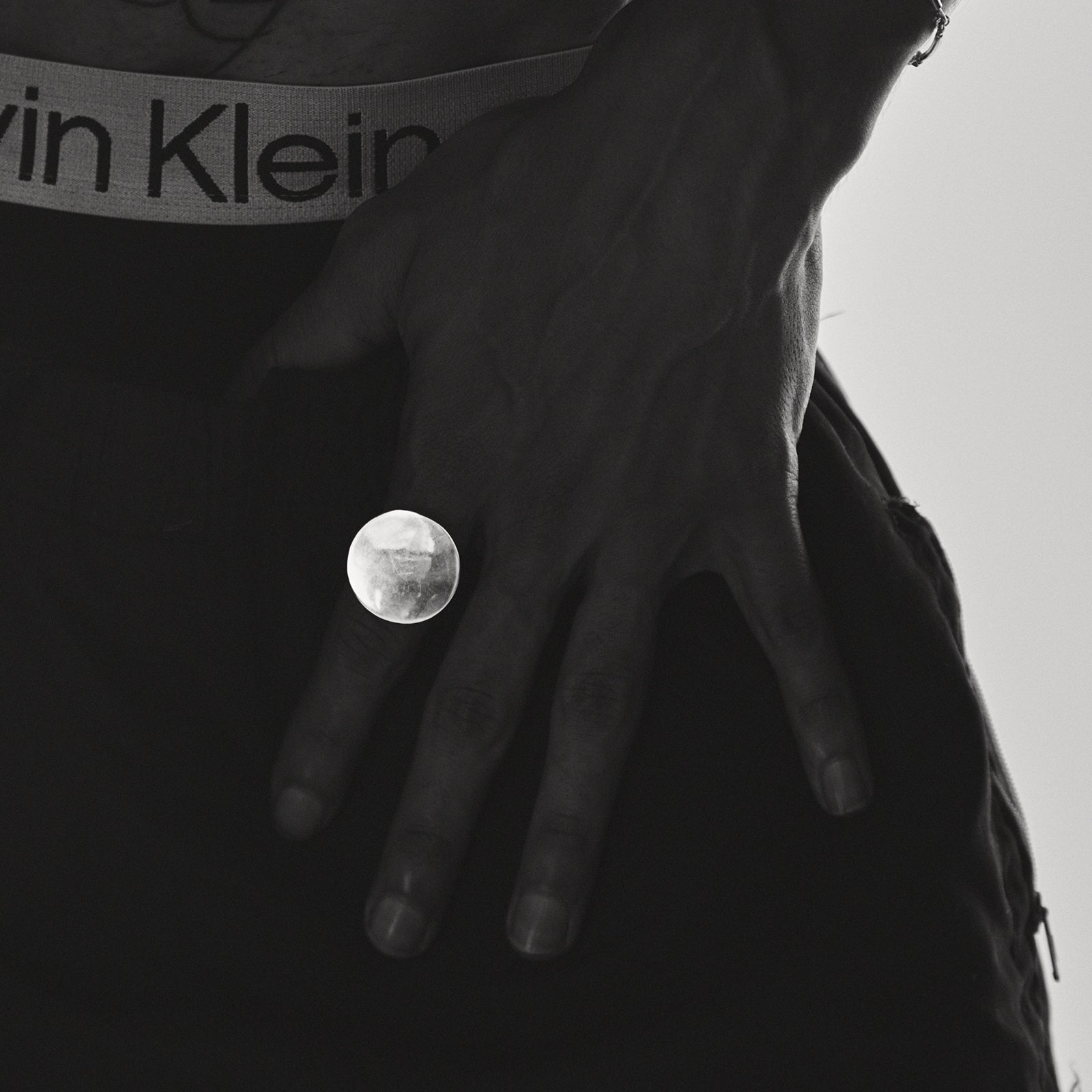 Person wearing a Calvin Klein belt with a close-up of the buckle.