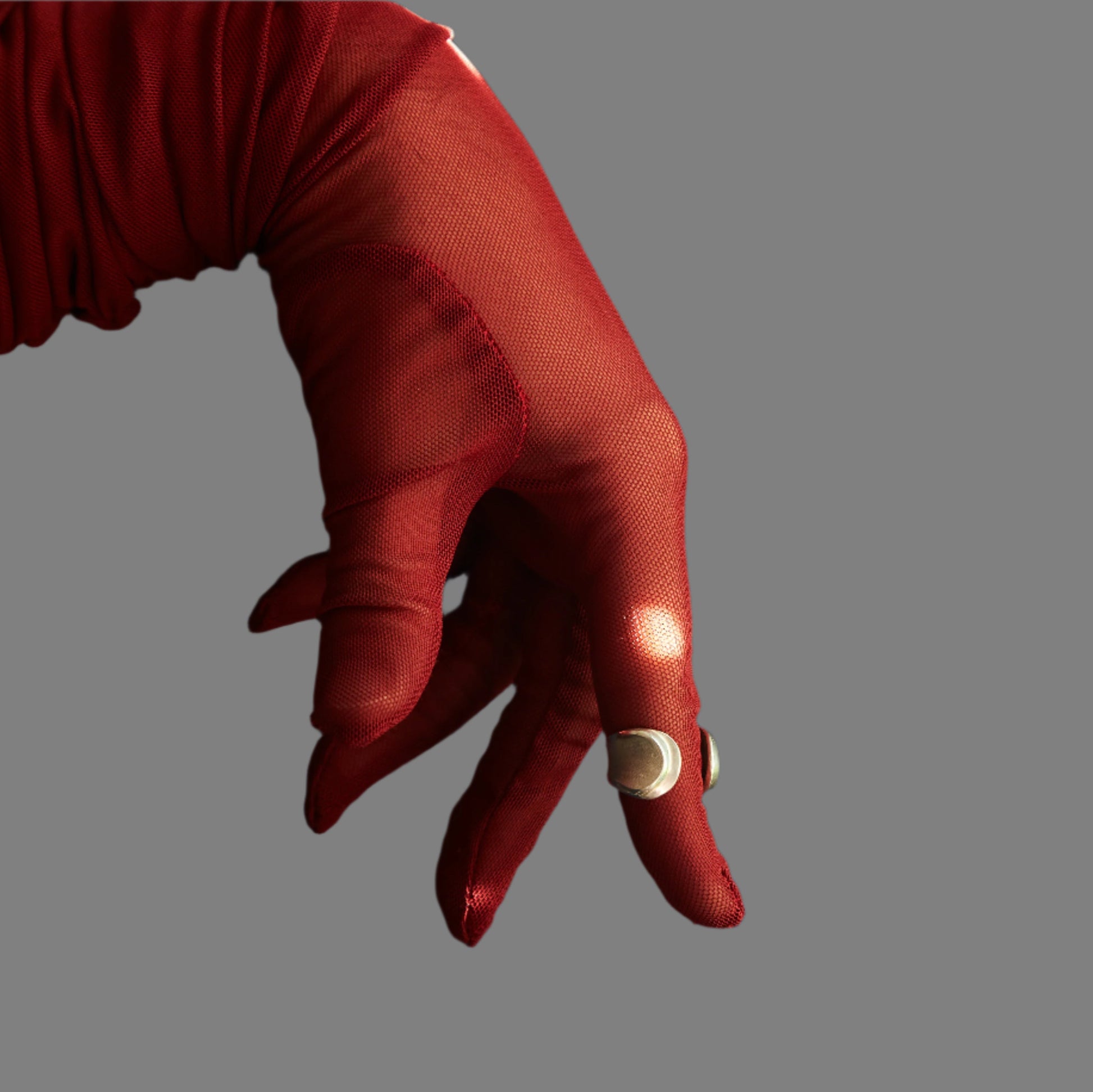 Red glove with a gold ring on a blue background