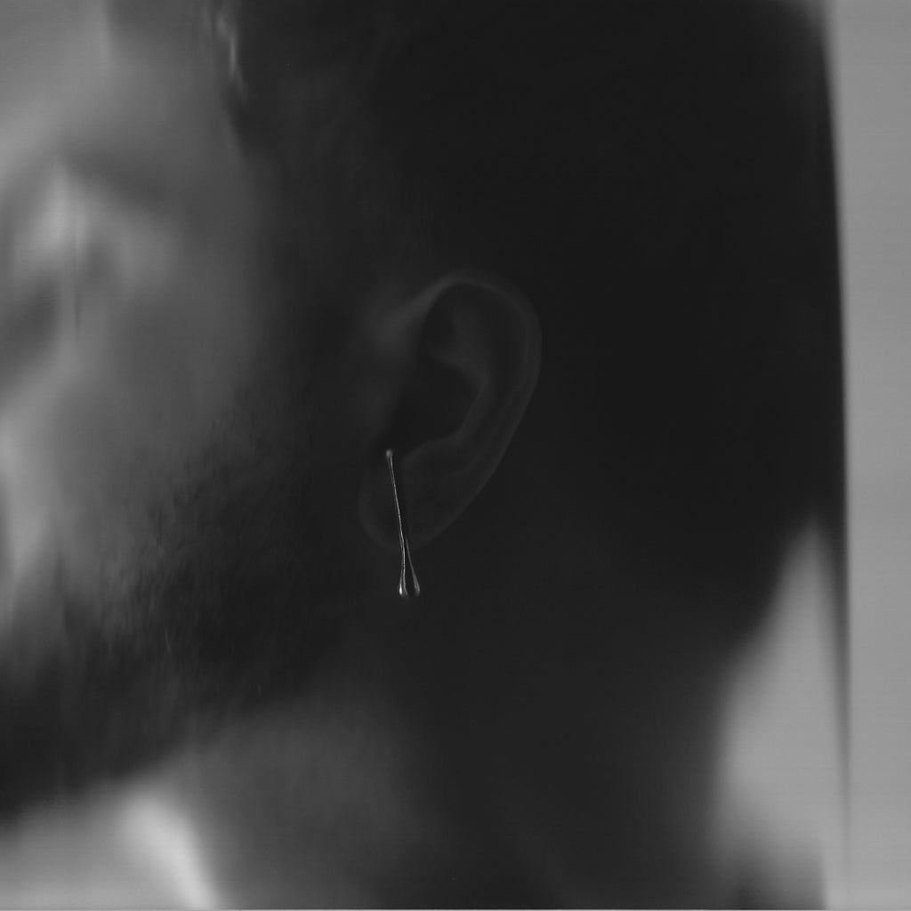 Close-up of a person wearing an earring with a blurred background