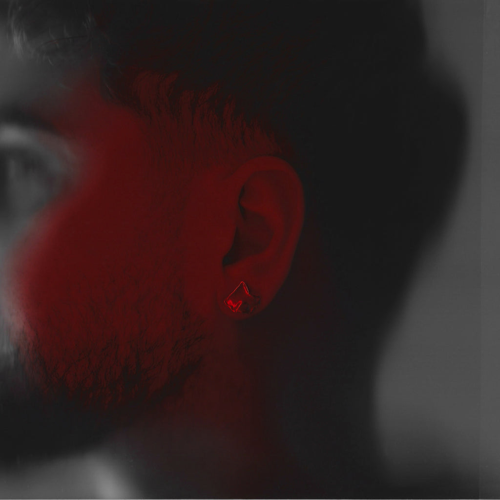Close-up of a person's ear with a red light, black and white background