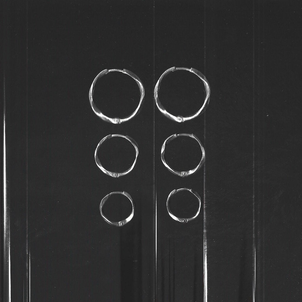 Set of silver hoop earrings on a gray background