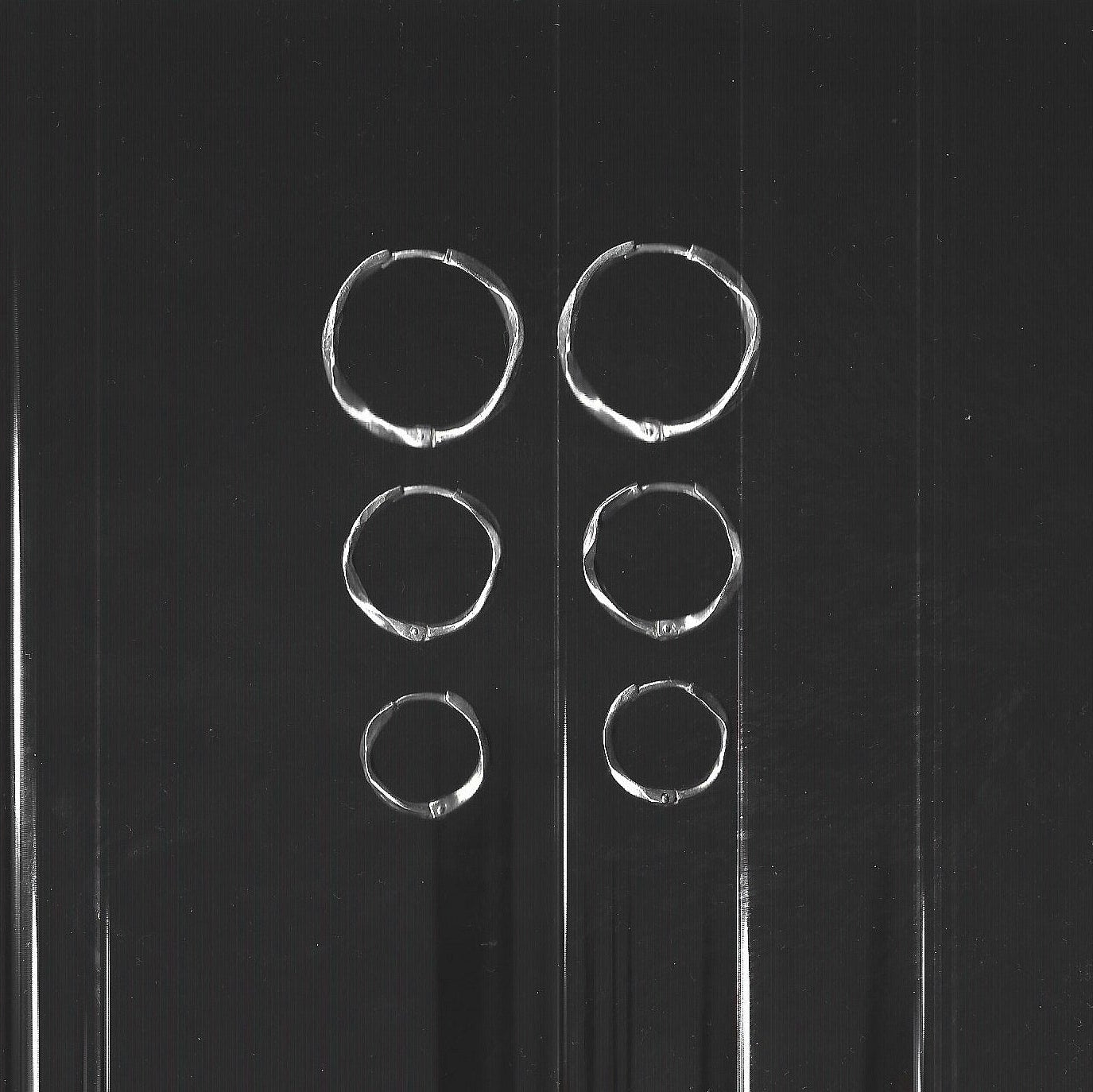 Set of silver hoop earrings on a gray background
