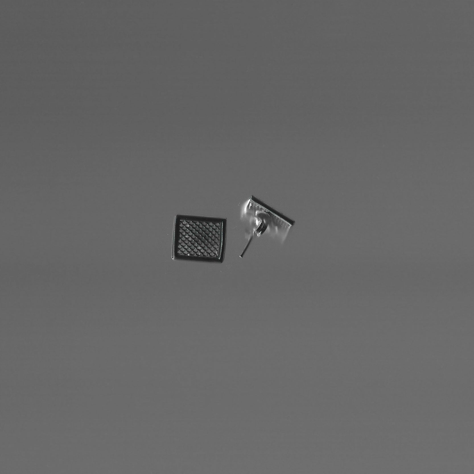 Two small square objects on a gray background