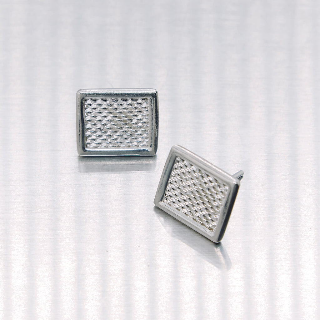 Pair of square silver earrings on a white background