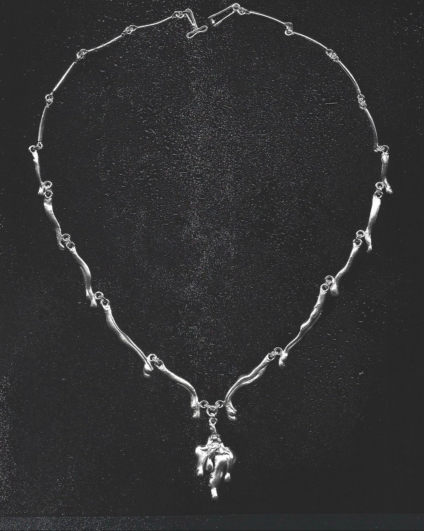 Silver necklace with a pendant on a black background
