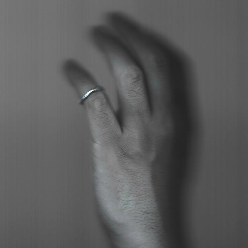 Hand with a ring on a plain background