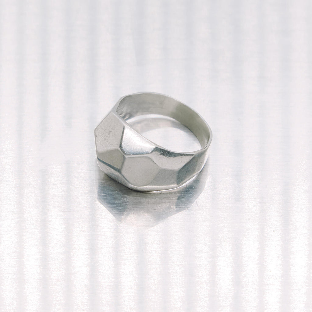 Silver geometric ring on a white background