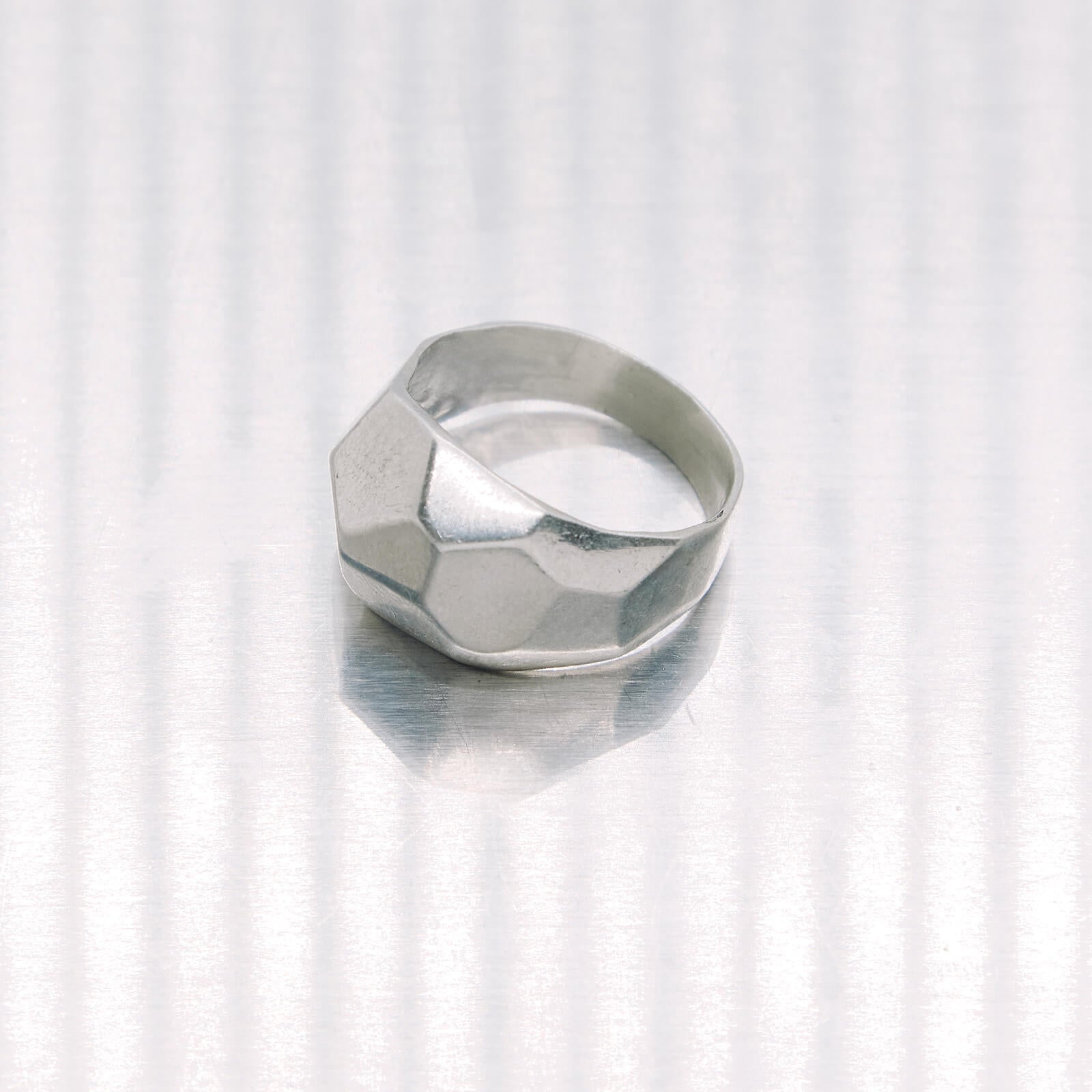 Silver geometric ring on a white background