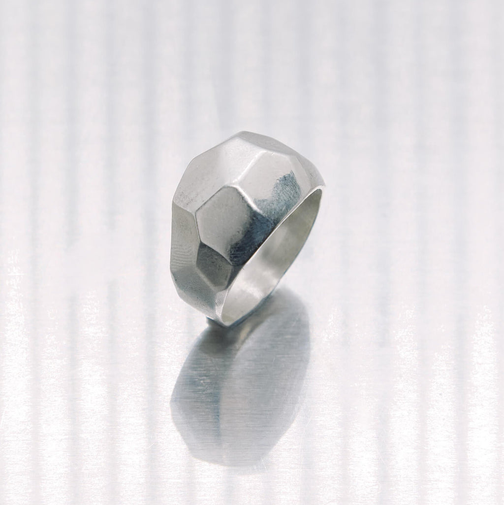 Silver ring with a geometric design on a white background
