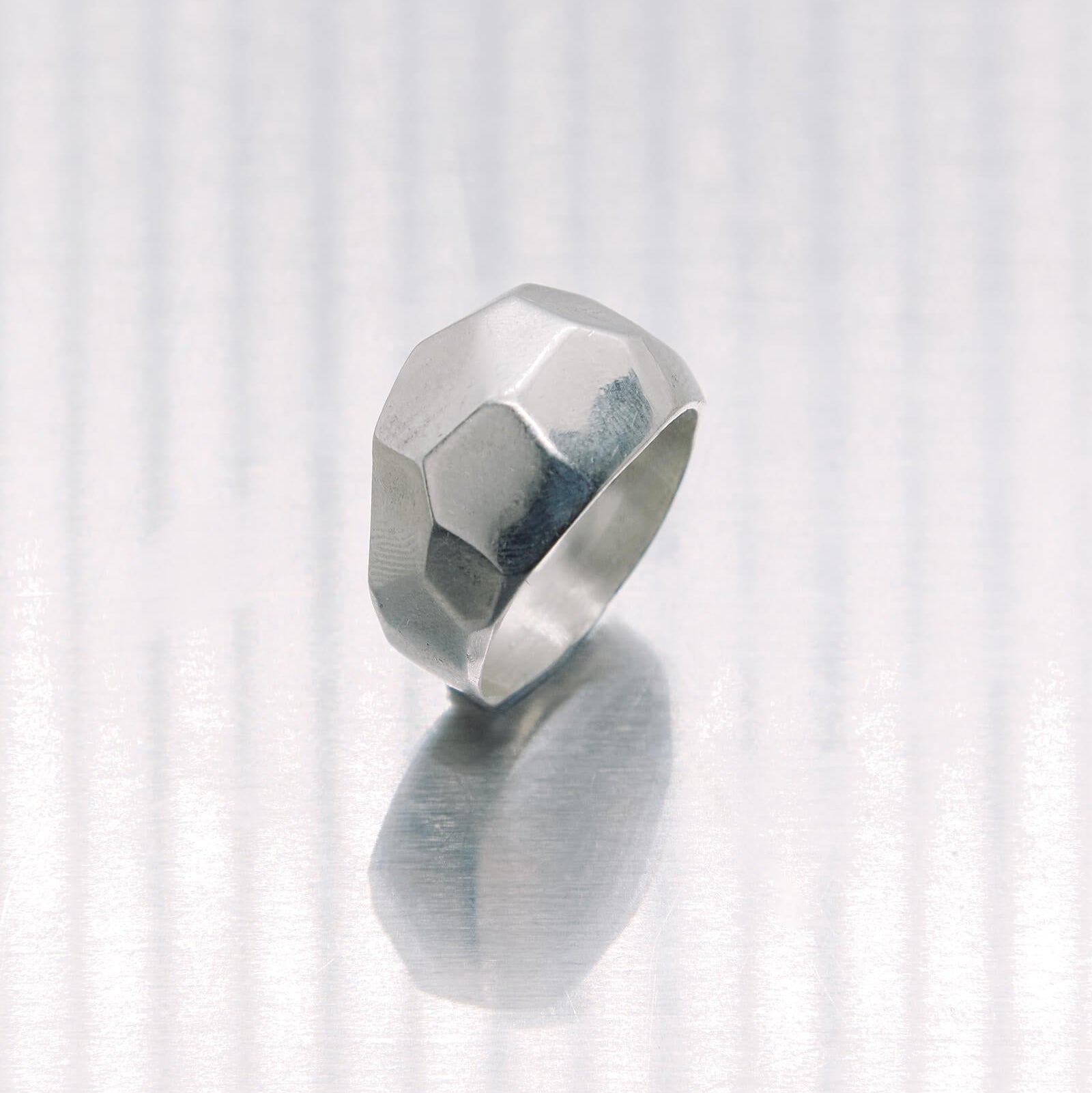 Silver ring with a geometric design on a white background