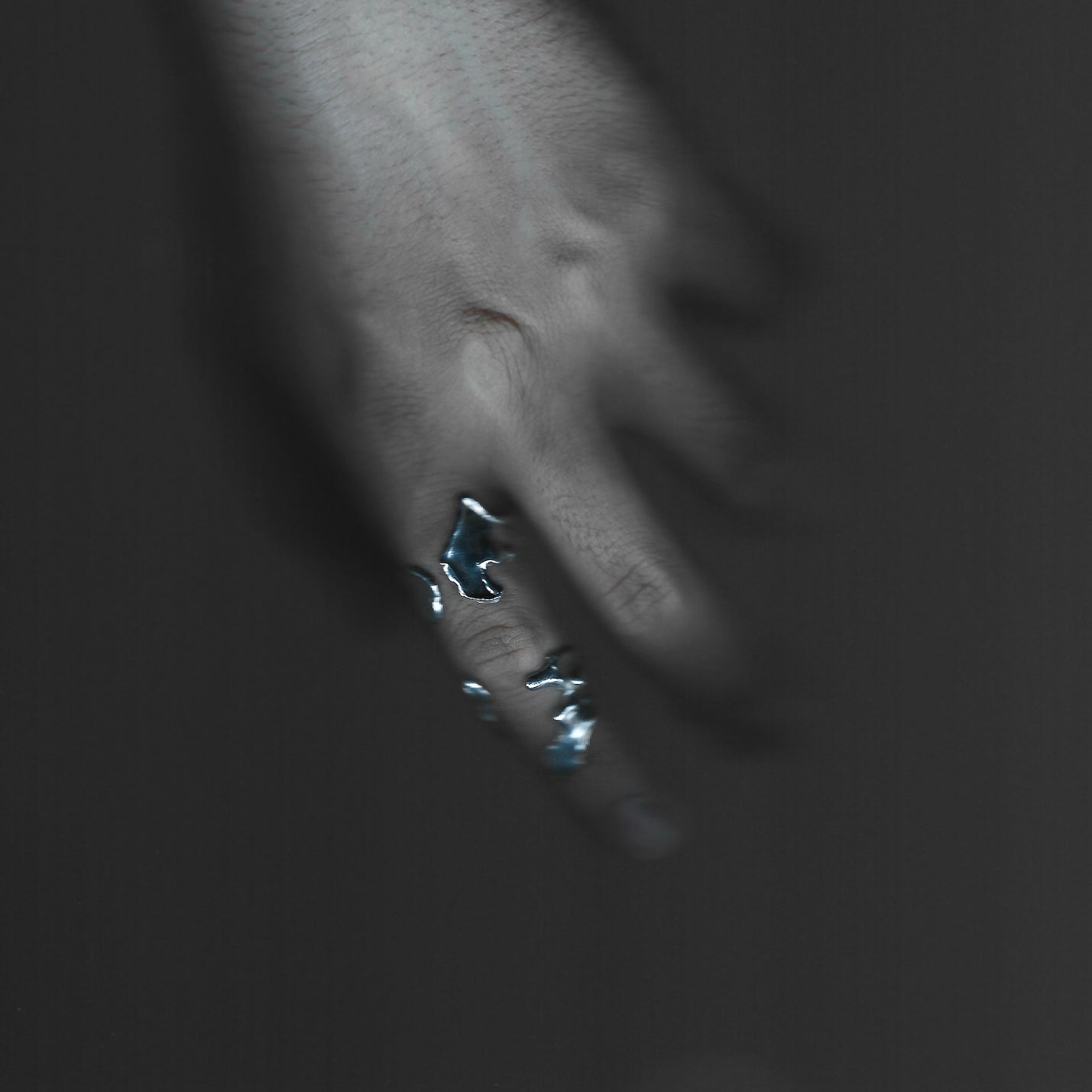 Close-up of a person's ear with a visible earring against a dark background