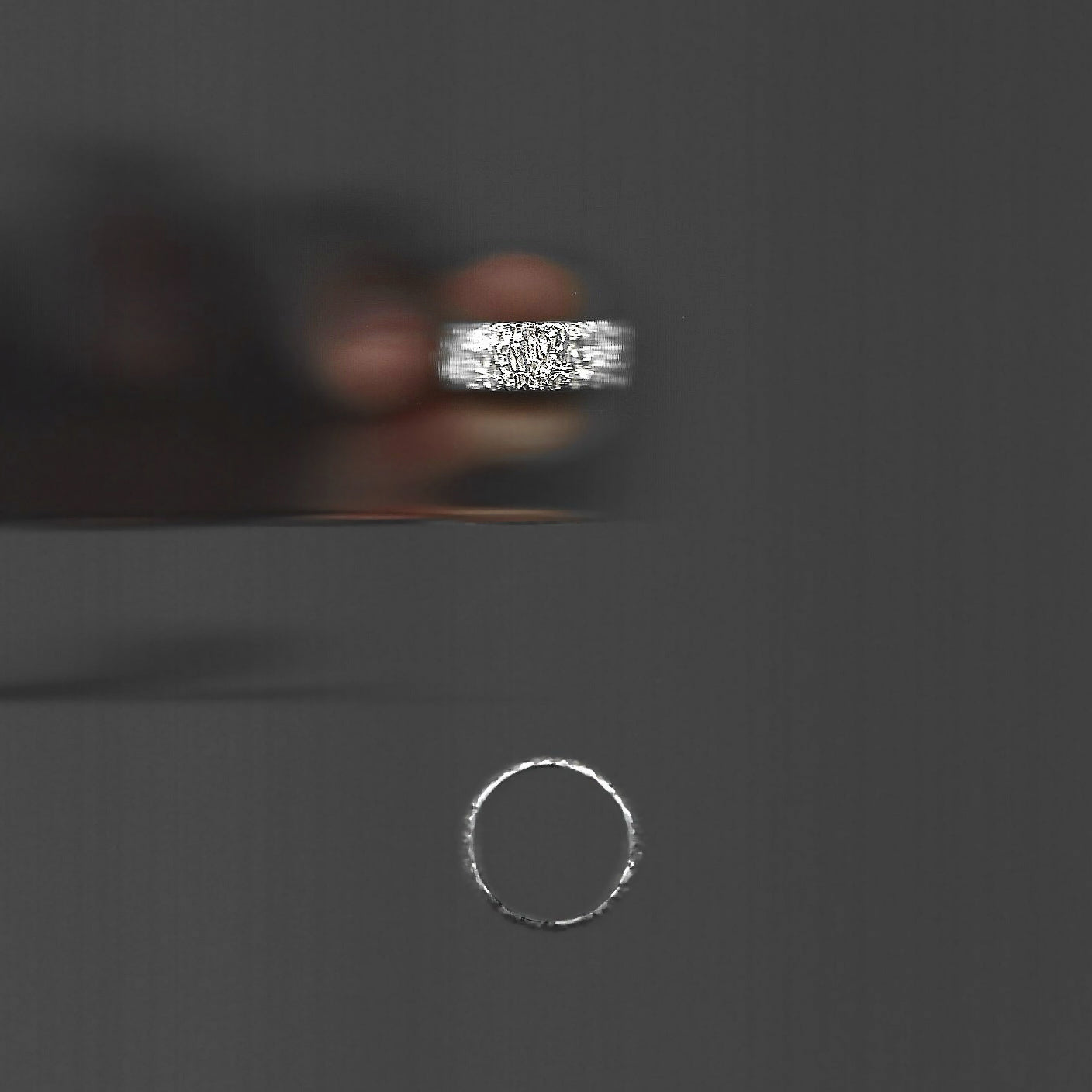 Close-up of a silver ring on a dark background