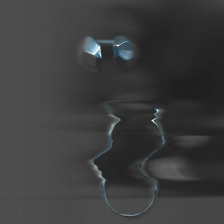 Two rings reflected in water on a dark surface