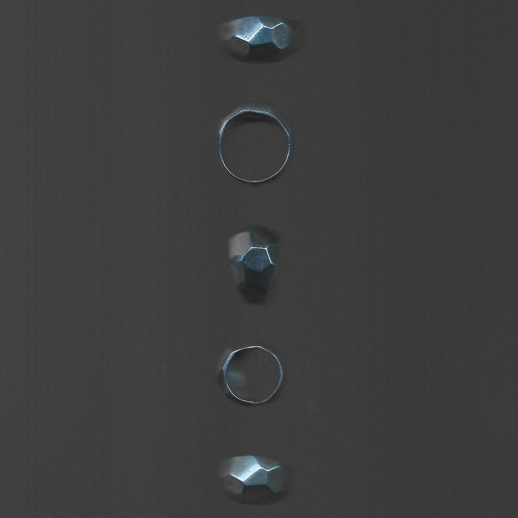 Five metallic rings of different sizes on a dark gray background