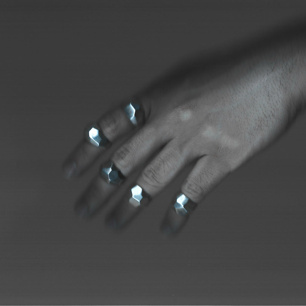 X-ray of a hand with metallic objects on a gray background