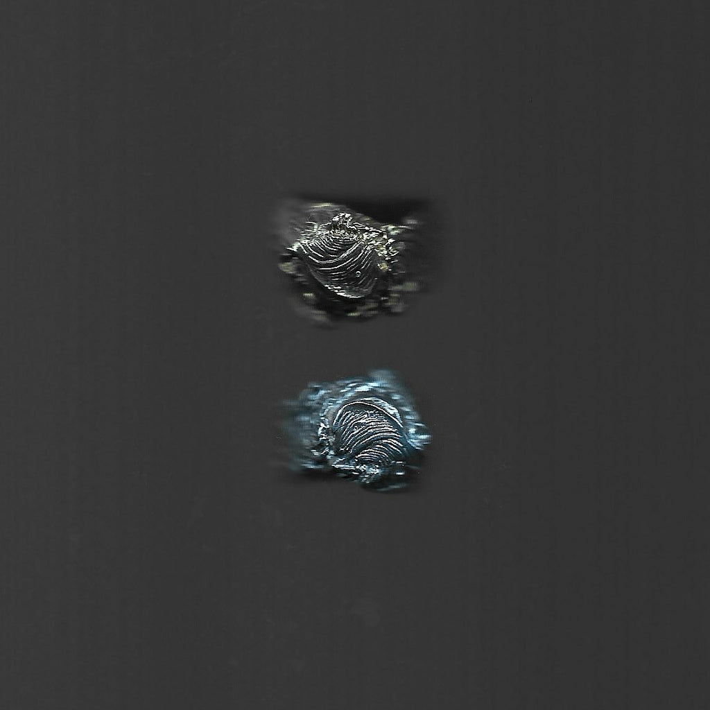 Two metallic objects on a dark gray background
