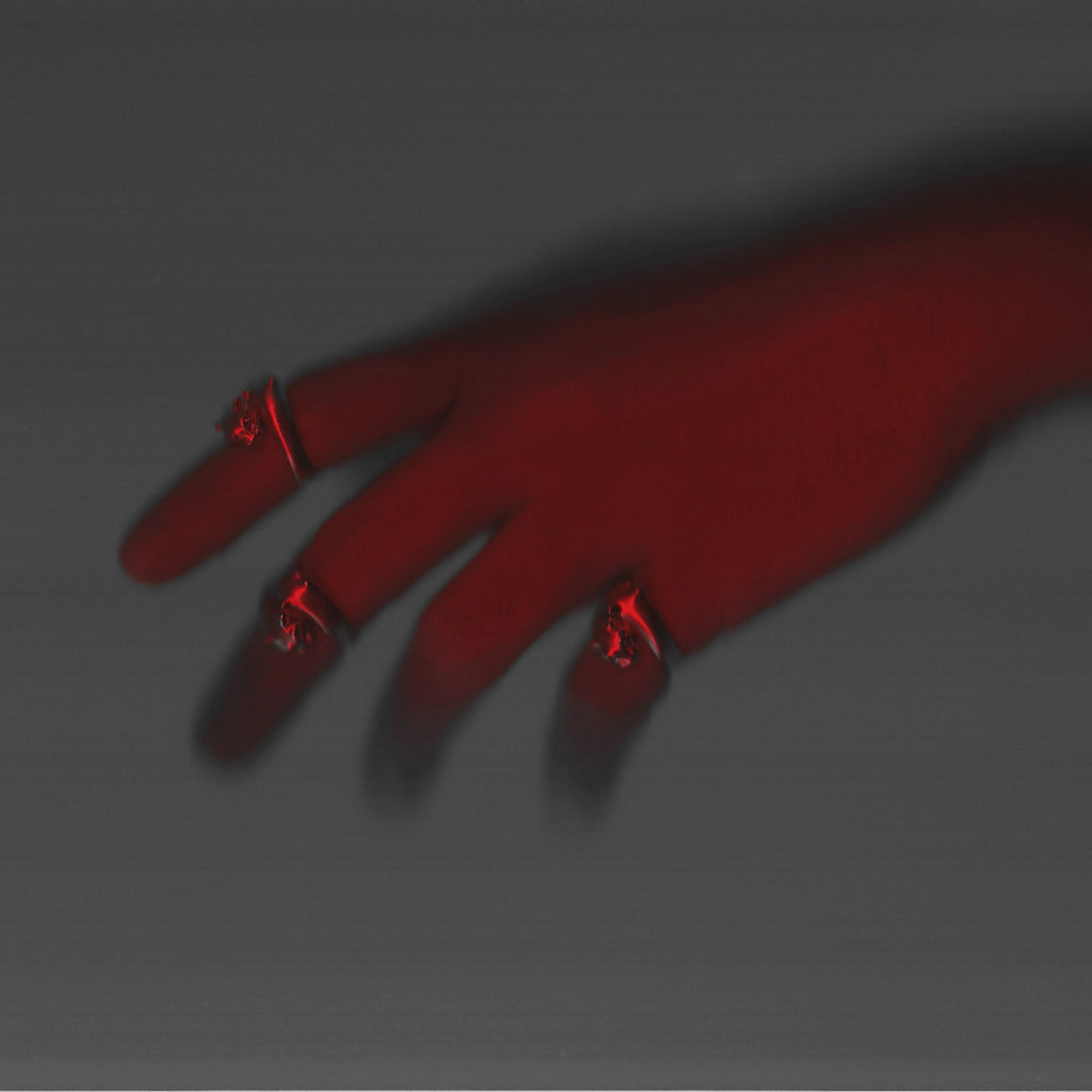 Hand with red nail polish on a dark background