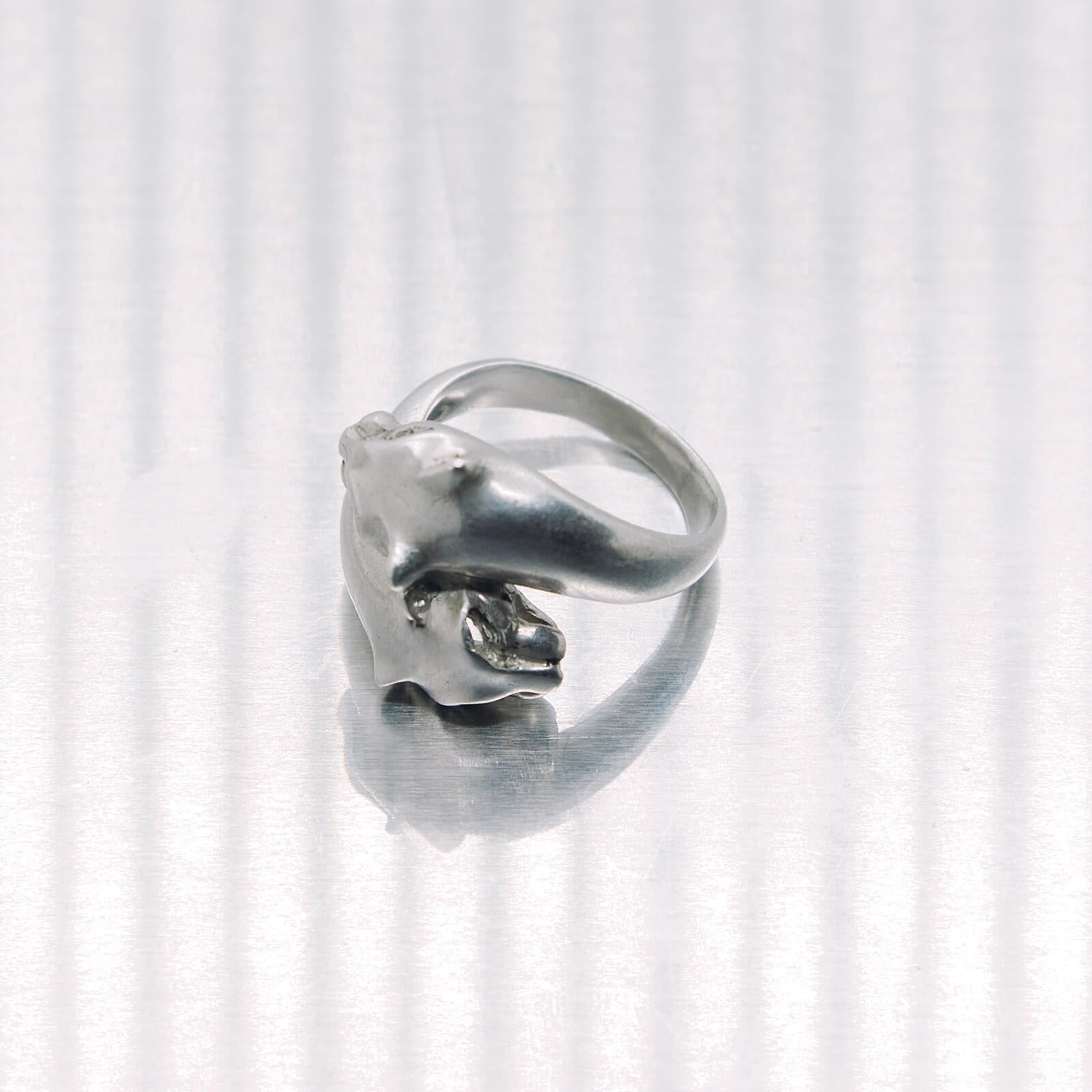 Silver ring with a tiger design on a white background
