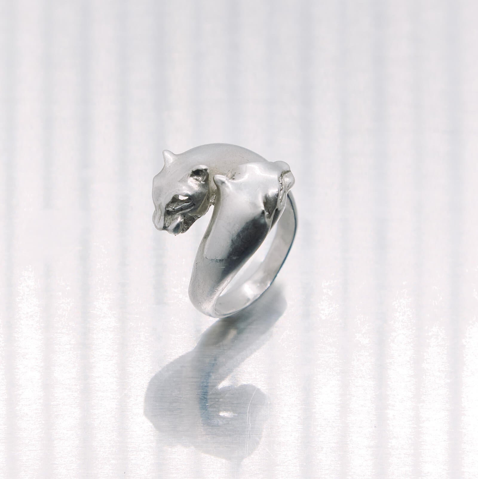 Silver ring with a tiger head design on a white background