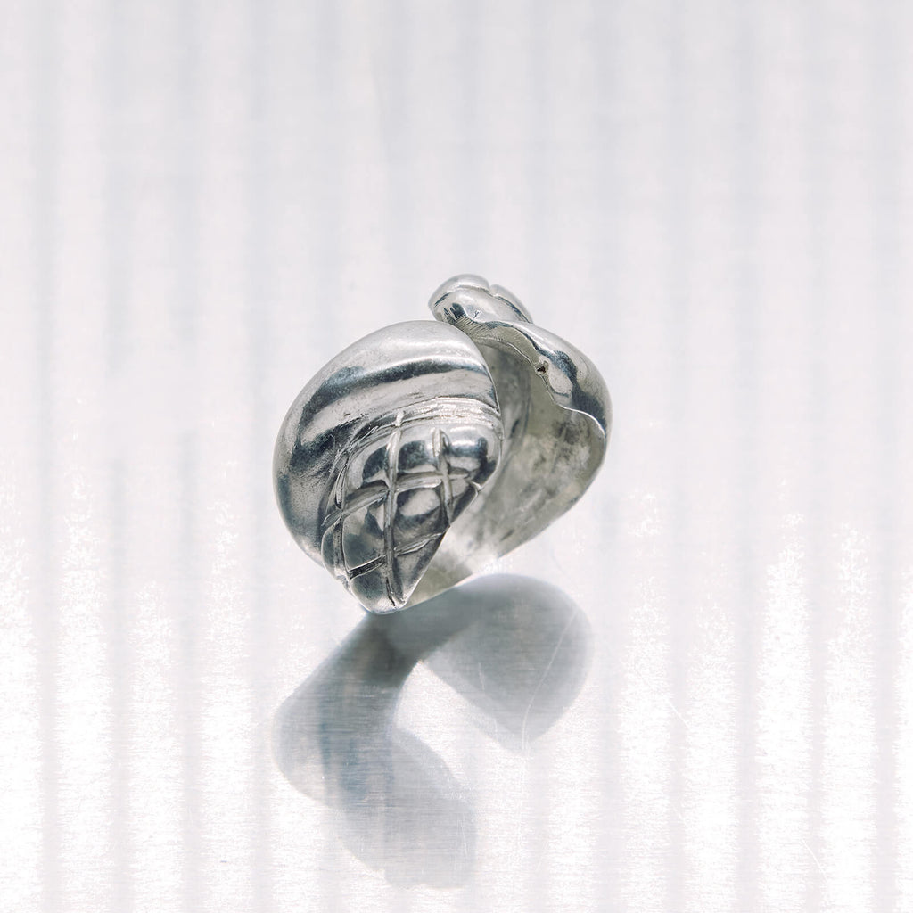 Silver ring with intricate design on a white background