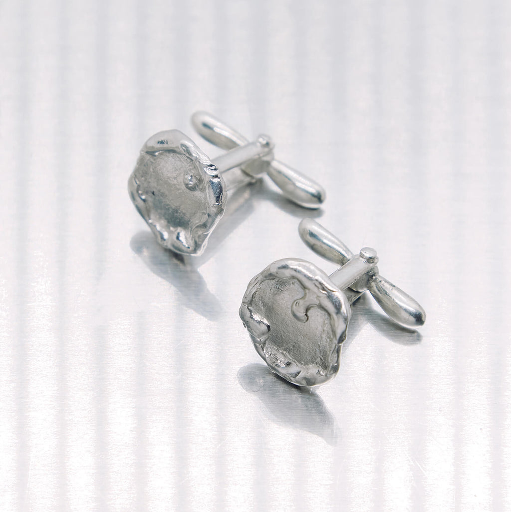 Pair of silver cufflinks on a white background