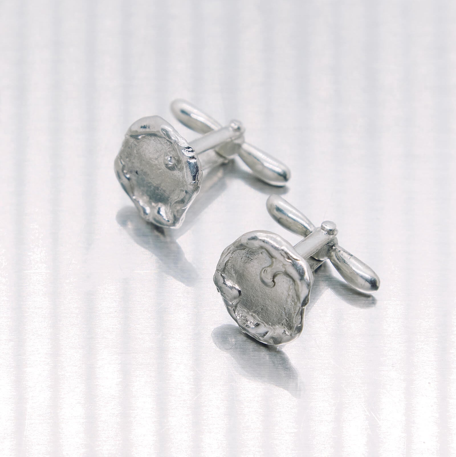 Pair of silver cufflinks on a white background