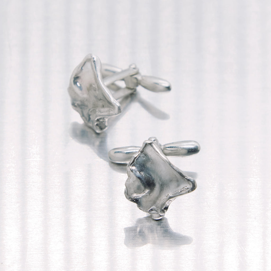 Pair of silver cufflinks on a white background