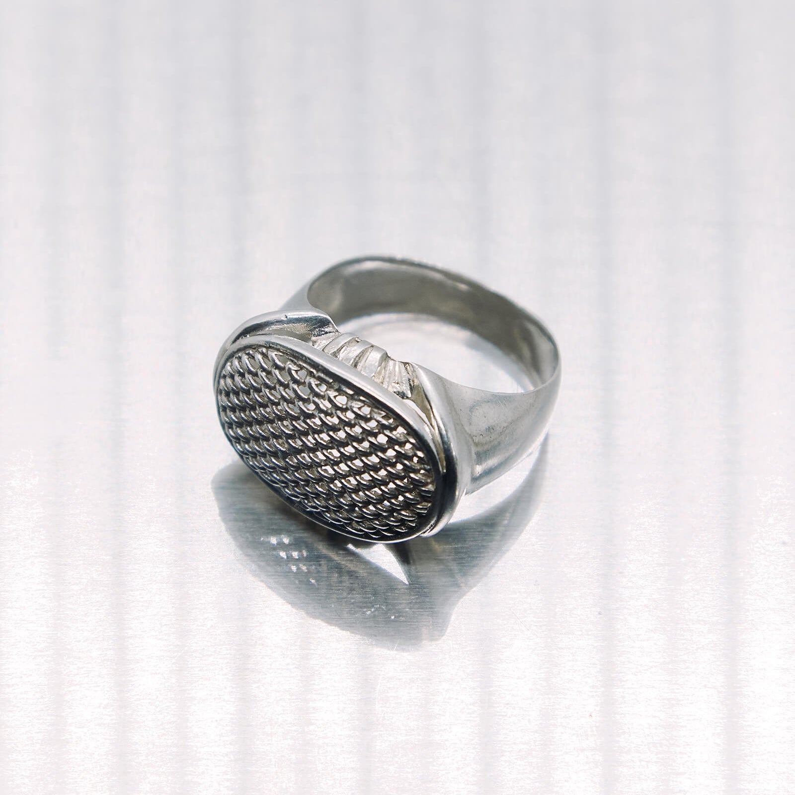 Silver ring with textured design on a white background